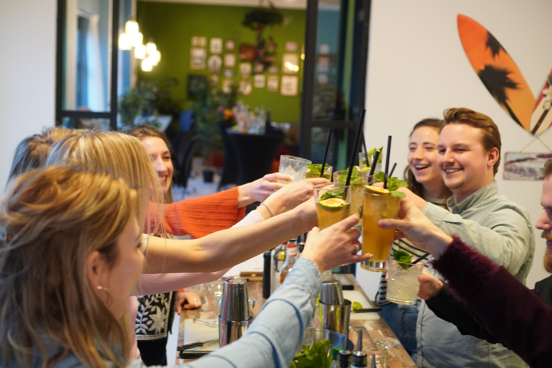 Deelnemers proosten samen na een cocktailworkshop